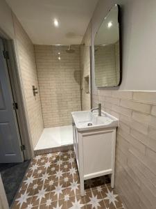 a bathroom with a sink and a shower with a mirror at The Pig and Whistle in London