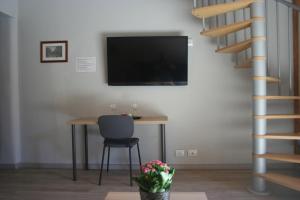 ein Esszimmer mit einem Tisch und einem TV an der Wand in der Unterkunft Katane Apartment One-Room in Catania