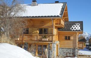 a log cabin with a snow covered roof at Odalys Chalet Jardin d'Hiver in La Toussuire