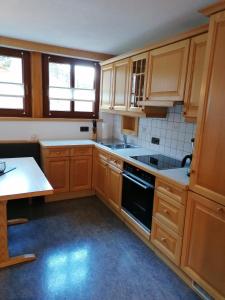 a kitchen with wooden cabinets and a black oven at Bichlerhof in Hopfgarten in Defereggen
