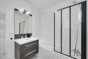 a white bathroom with a sink and a shower at Appartement ensoleillé avec vue sur Paris et le Sacré-Cœur by Weekome in Paris