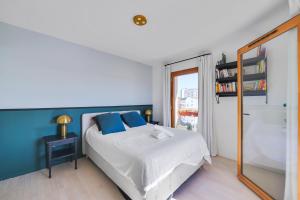 a bedroom with a bed with blue walls and a mirror at Appartement ensoleillé avec vue sur Paris et le Sacré-Cœur by Weekome in Paris