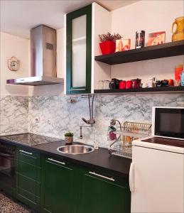 eine Küche mit grünen Schränken und einem Waschbecken in der Unterkunft Heart of the City in Banja Luka