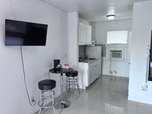 a kitchen with a table and stools in a room at Sunshine Inn of Miami in Miami