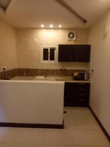 a kitchen with a white counter and a sink at بيوتات الزير in Al Baha