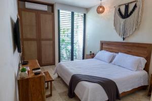 Un dormitorio con una cama grande y un televisor. en Exquisite Tulum jungle condo w/private pool!, en Tulum 16 fotos más