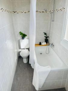 a bathroom with a tub and a toilet and a sink at -The Urbanist- Lakeview Free Parking 2BD Fast WiFi in Oberhofen am Thunersee