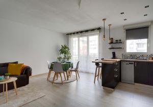 cocina y sala de estar con mesa y sofá en Au COEUR du STADE DE FRANCE, en Saint-Denis