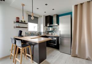 a kitchen with a counter and a refrigerator at Au COEUR du STADE DE FRANCE in Saint-Denis