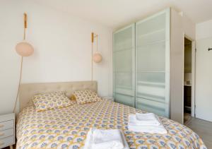 een slaapkamer met een bed met twee handdoeken erop bij Au COEUR du STADE DE FRANCE in Saint-Denis