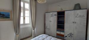 ein Schlafzimmer mit einer Kommode und einem Bett darin in der Unterkunft L'AIRONE - casa vacanza in Mandello del Lario