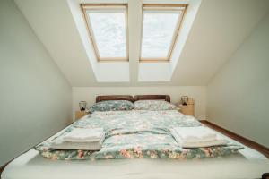 ein Schlafzimmer mit einem Bett mit zwei Kissen und einem Fenster in der Unterkunft ČÁKYHO KÚRIA - apartmán pre 5 osôb s krbom a saunami in Smižany