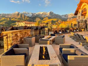 une terrasse avec des canapés, une cheminée et des montagnes dans l'établissement Forbes 5 Star Luxury Hotel - 1 Br Residence in Mountain Village Colorado, à Telluride