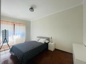 - une chambre blanche avec un lit et une fenêtre dans l'établissement LX Factory Lisboa Apartament, à Lisbonne