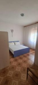 a bedroom with a blue bed and a wooden floor at Teulada vacanze in Teulada