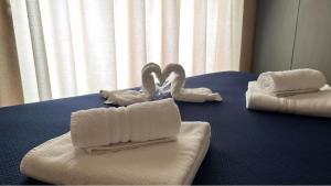 a blue table with towels on a bed at ALMA B&B Home Cosenza in Cosenza