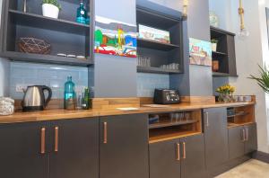 a kitchen with gray cabinets and wooden countertops at The Muse - Luxury 5 Bedroom House in Belfast