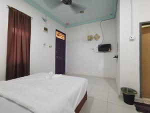 a bedroom with a white bed and a black door at RVH Kuala Terengganu in Kuala Terengganu