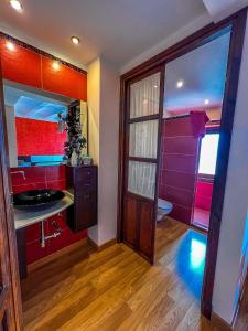 baño con paredes rojas y moradas y lavabo en VTAR Casa las Tinajas, en Baeza