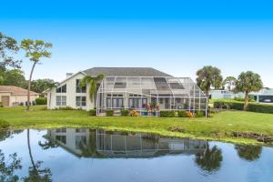 a house with a conservatory next to a pond at Paradiso Probay in Bradenton