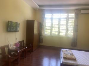 a living room with a table and a bed and a window at Trung Đức Hotel in Hòn Một