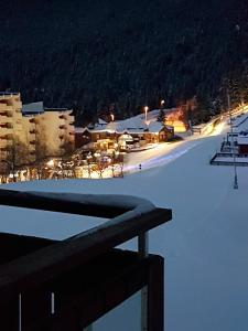 a view of a ski resort in the snow at night at Edelweiss Prapoutel les 7 Laux in Les Adrets