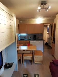 eine kleine Küche mit einem Holztisch und einem Esszimmer in der Unterkunft Edelweiss Prapoutel les 7 Laux in Les Adrets