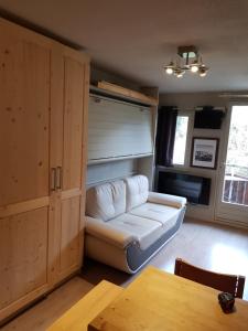 ein Wohnzimmer mit einem weißen Sofa und einem Tisch in der Unterkunft Edelweiss Prapoutel les 7 Laux in Les Adrets
