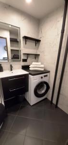 a bathroom with a washing machine and a sink at HAPPY - VIP Apartment - ApartamentyHappy pl in Tarnów