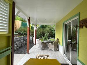 un patio con mesa y sillas en una terraza en Villa Diam-Arlet en Les Anses-dʼArlets