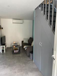 salon z kanapą i schodami w obiekcie Maison en bord de mer w mieście Mauguio