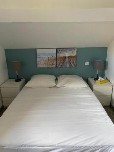 1 dormitorio con 1 cama blanca grande y 2 lámparas en Maison en bord de mer en Mauguio