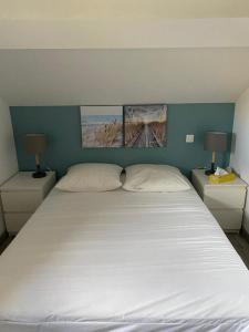 sypialnia z dużym białym łóżkiem z 2 lampami w obiekcie Maison en bord de mer w mieście Mauguio
