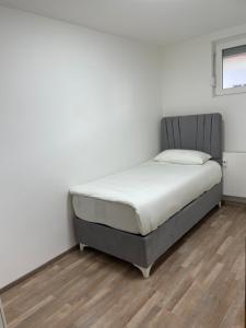 een bed in een kamer met witte muren en houten vloeren bij Erbacher Wohnung in Erbach