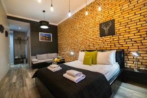 Un dormitorio con una pared de ladrillo y una cama en Leo Apartments Main Square, en Cracovia