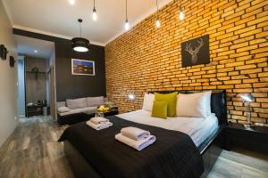 a bedroom with a brick wall and a bed at Leo Apartments Main Square in Krakow