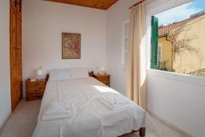 - une chambre blanche avec un lit et une fenêtre dans l'établissement Alekos House, à Longós