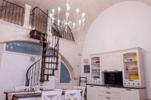una cucina con lampadario pendente, tavolo e sedie di La casa di Jannina a Fasano