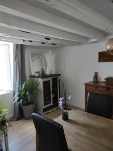 uma sala de estar com uma mesa, uma cadeira e uma lareira em Agréable chambre d'hôte 