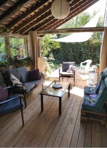 uma sala de estar com sofás e uma mesa de centro em Agréable chambre d'hôte 