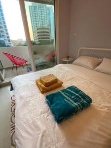 a white bed with a blue bag on top of it at Studio apartment in the heart of Dubai Marina. in Dubai
