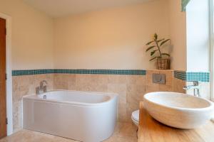 baño con bañera blanca grande y aseo en Tinkers Folly, en Harrogate 40 fotos más