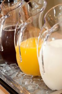 two glass containers of orange juice and a jug of milk at Citadines Central Shinjuku Tokyo in Tokyo