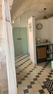 eine Küche mit einem karierten Boden und einer grünen Tür in der Unterkunft La casetta in Putignano