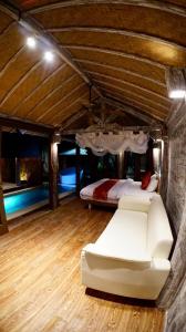Cette chambre comprend un canapé blanc et un lit. dans l'établissement PROMO! Private Vacation Rentals Villa, 2 Pools,4 Bedrooms,4 Bathrooms, Bali Seminyak, à Seminyak