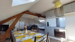 a kitchen and dining room with a table in a room at Studio tout confort 2 personnes en plein centre ville in Roye