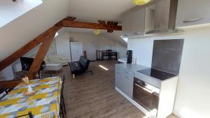 a kitchen and a living room with a table and a kitchen and a living room at Studio tout confort 2 personnes en plein centre ville in Roye +3 photos