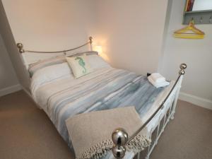 een slaapkamer met een bed met een wit bedframe bij Salt Cottage in Redcar