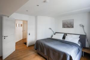 een slaapkamer met een bed met witte muren en houten vloeren bij LOFT13 Traumhafte Wohnung mit Terrasse für 4 Gäste in Monschau