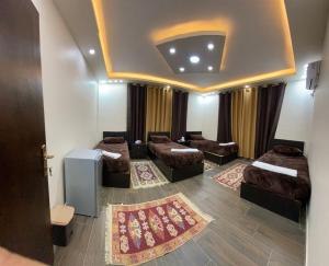 une chambre avec quatre lits et une chambre avec des rideaux dans l'établissement Petra Olive House, à Wadi Musa